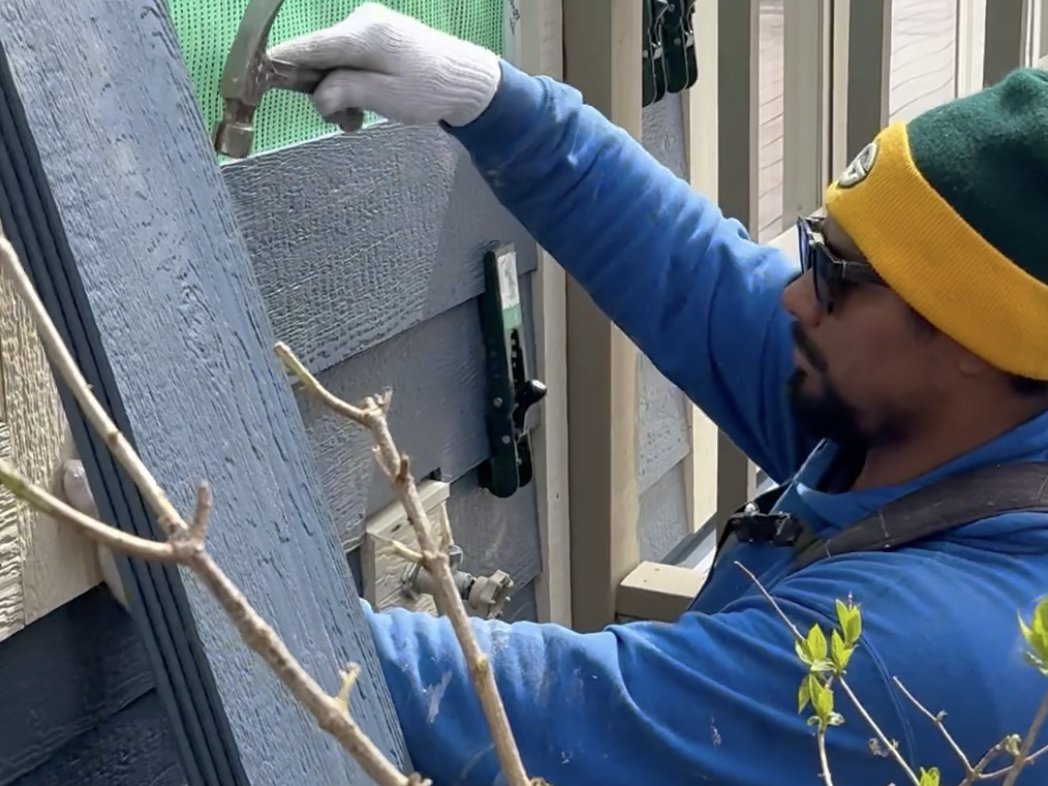 Siding repair LeFever Roofing crew member repairing siding